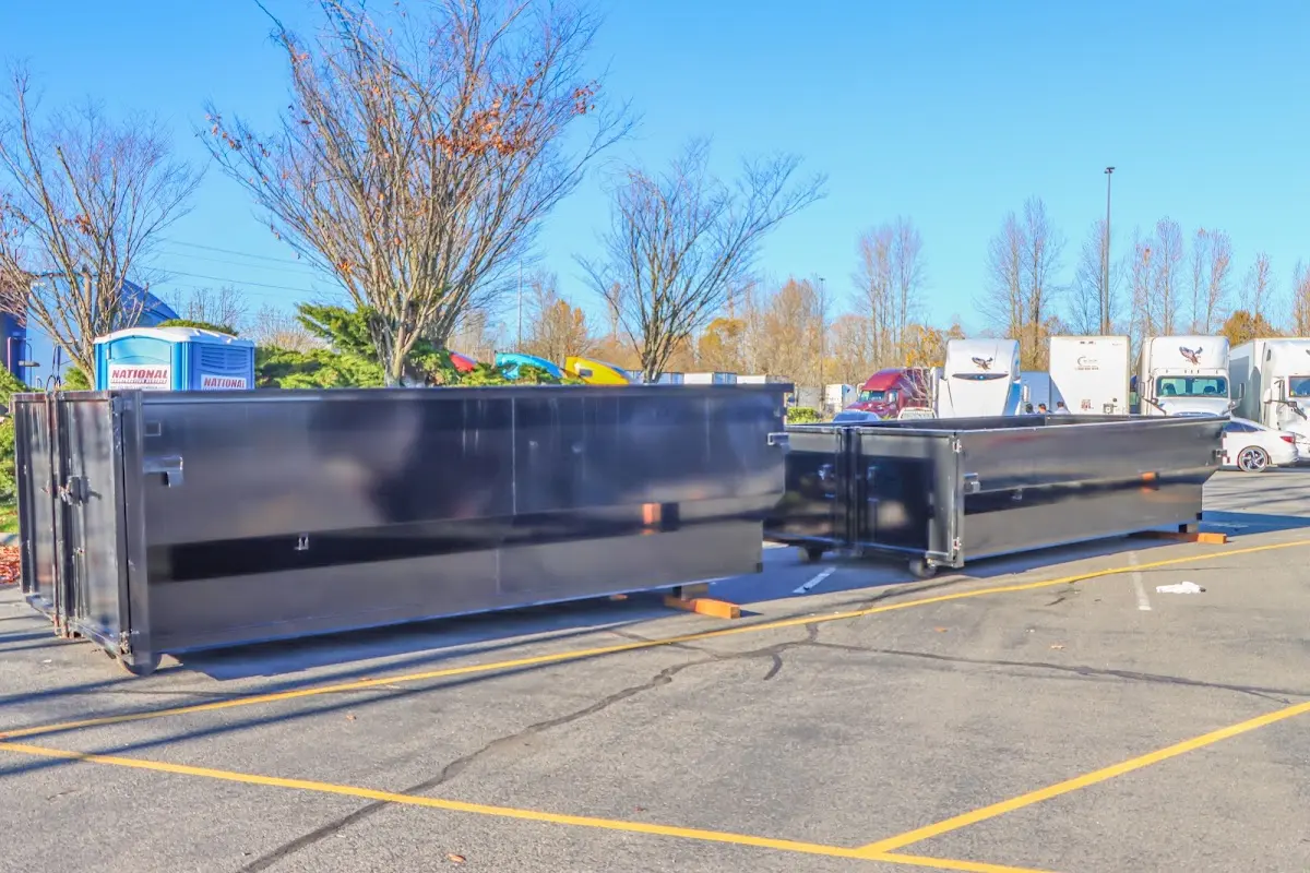 Professional dumpster rental service with roll-off container on residential driveway in Warwick